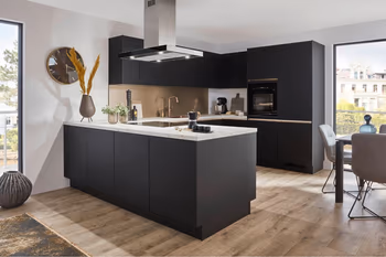 Auf dem Bild ist eine schware Küche mit heller Arbeitsplatte. Es handelt sich um eine große Küche mit einer Kücheninsel in moderner, grifflosen Ausführung und einer Inselhaube.